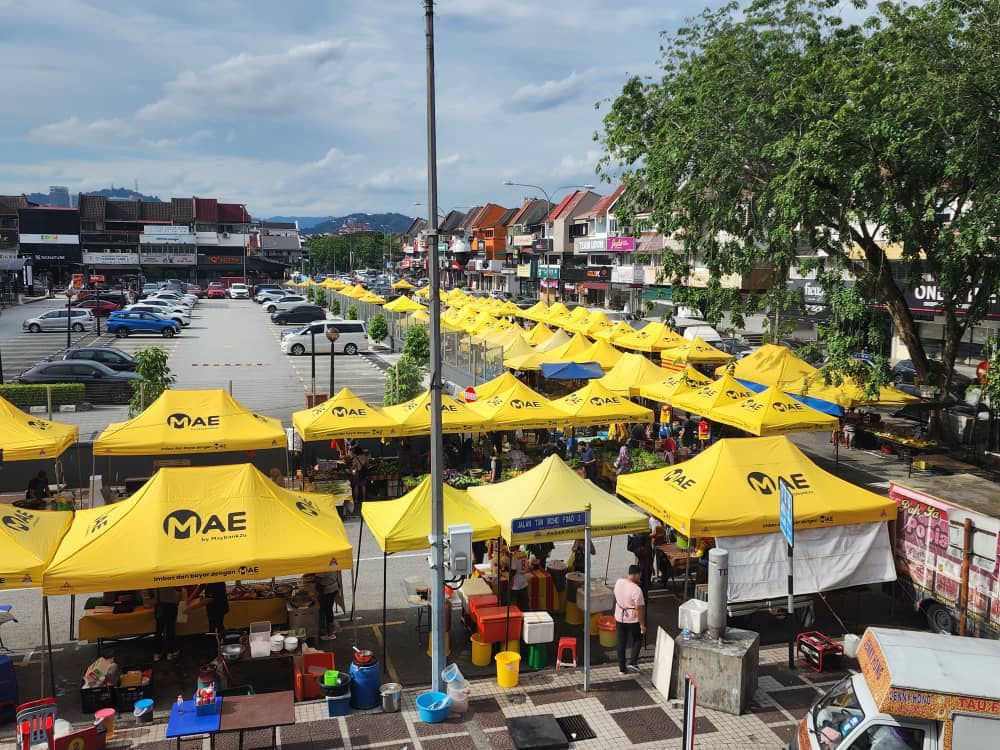 A row of yellow Joo East canopies at a market