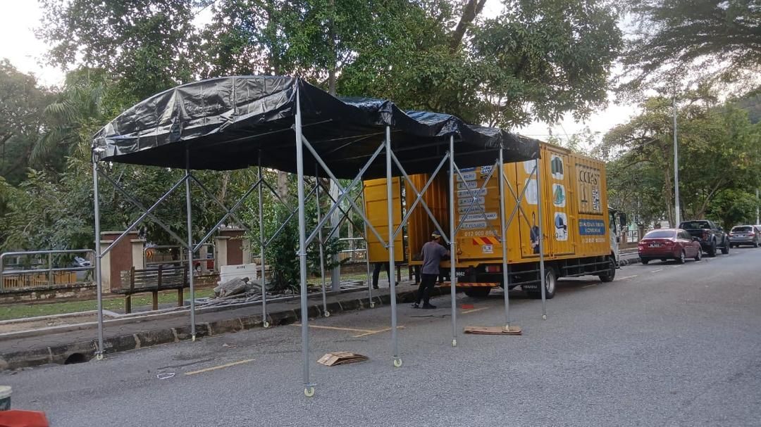 Black halfmoon canopy being installed by the roadside